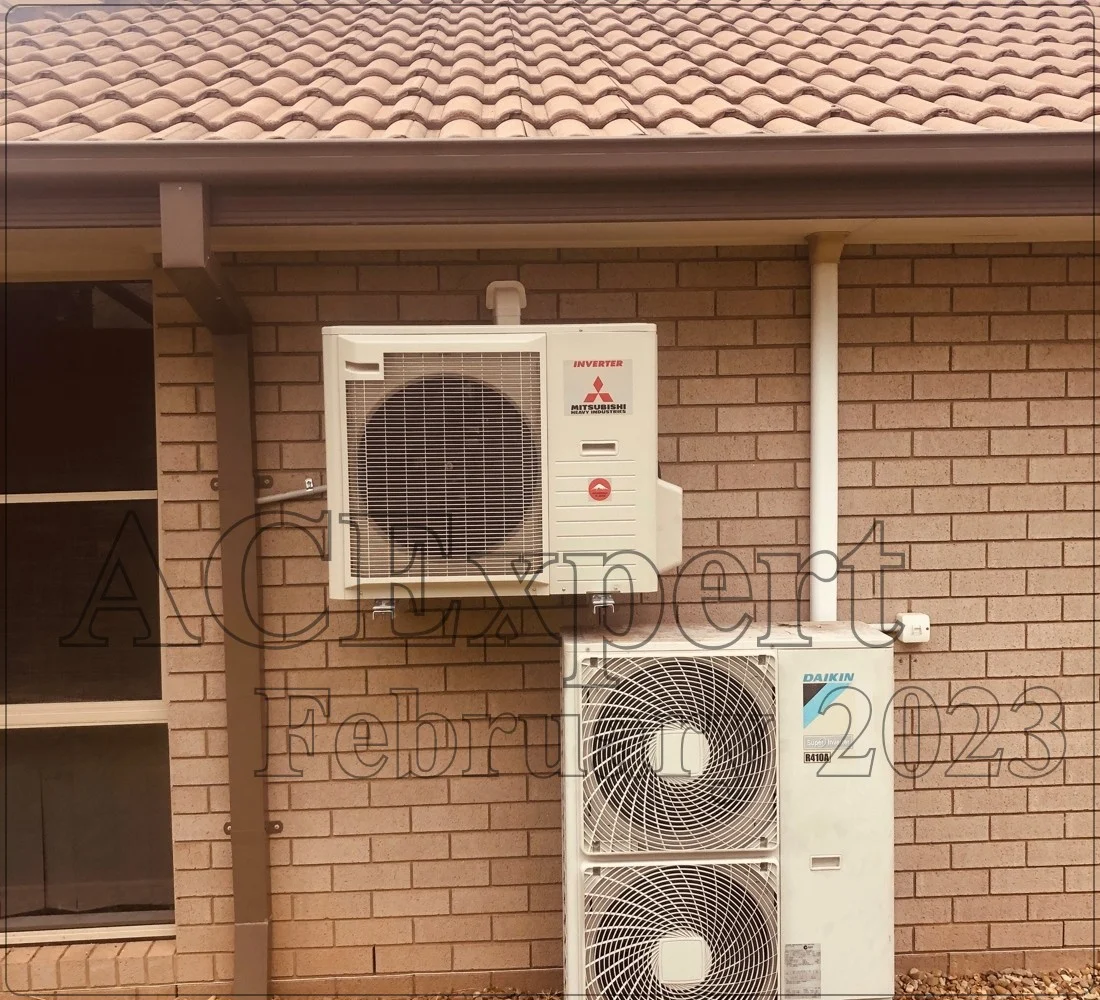 Technicians demonstrate split system installation by showing where to mount the outdoor unit on a Brisbane home