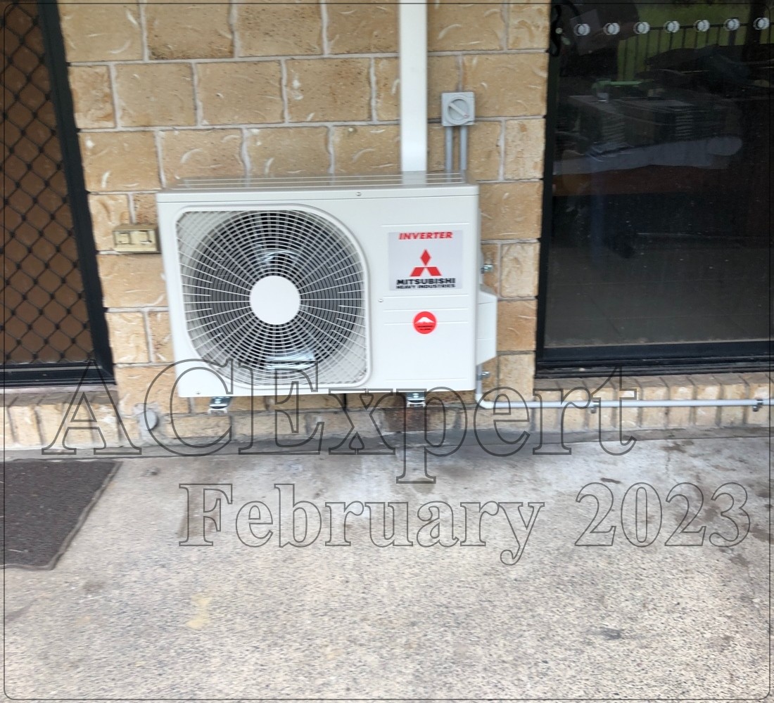 Wall mounted split system with digital remote control display HVAC technician tightening electrical connections on an outdoor air conditioning unit in Brisbane