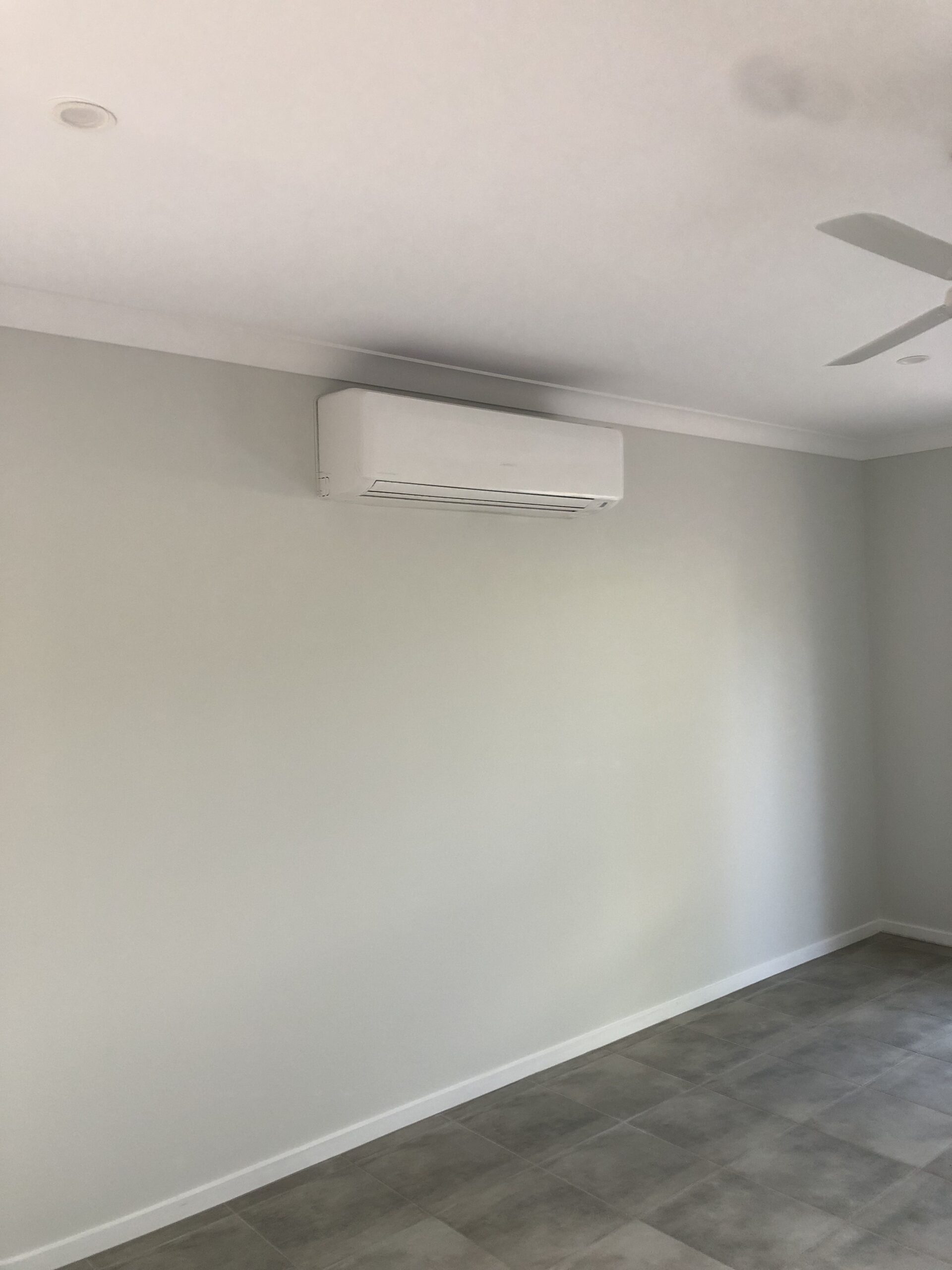 Air duct plenum in the ceiling with flexible branches connected to multiple room vents